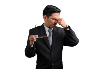 Handsome Asian businessman in suit rubbing eyes while holding glasses, feeling tired, stressed or frustrated, isolated on transparent background