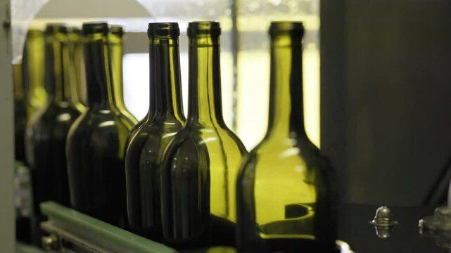 Wine production line : industrial machine in wine factory. bottles with wine on bottling and sealing conveyer production line