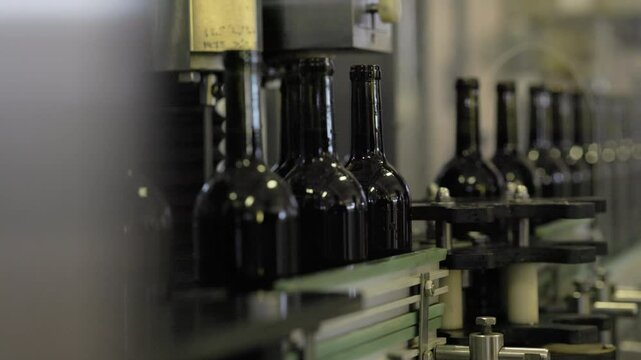 Wine production line : industrial machine in wine factory. bottles with wine on bottling and sealing conveyer production line