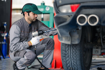 Professional technicians conduct vehicle diagnostics and maintenance with precision. In the workshop, a skilled mechanic changes a tire, A concept of the automotive industry, and customer service.