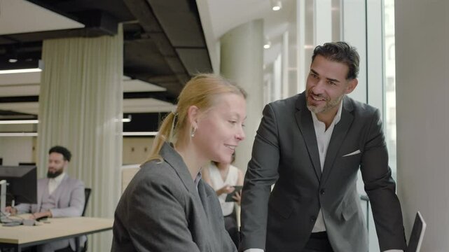 In a modern, contemporary office setting, a diverse group of business professionals come together to collaborate effectively, showcasing the importance of teamwork and open communication among them