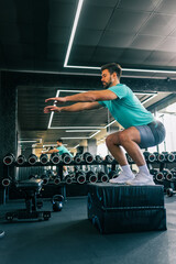 Athletic man jumping during a workout in the gym...