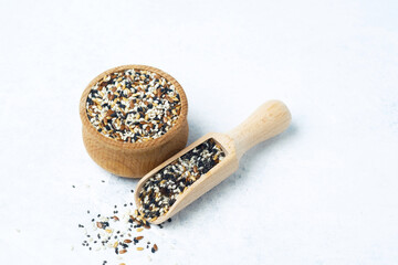 Spice blend in wooden bowl with scoop on light textured background