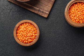 Bright orange lentils showcase natural color and texture in wooden bowls