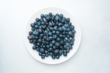 Fresh blueberries arranged neatly on a white plate ready for consumption