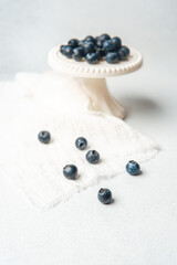 Fresh blueberries arranged on a small pedestal with some scattered around