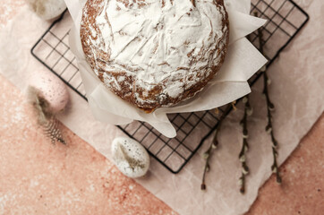 Traditional Easter cake with powdered sugar and speckled eggs on parchment paper. Festive food concept for spring holiday.