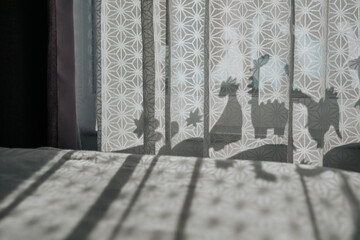Nursery room with dinosaur shadows on curtain.