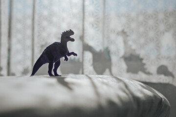 Nursery room with dinosaur shadows on curtain.