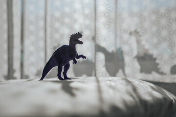 Nursery room with dinosaur shadows on curtain.