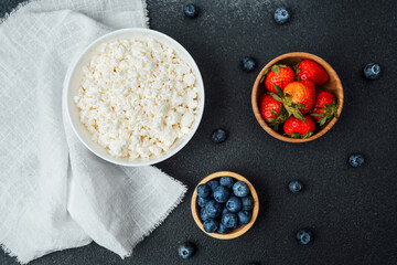 Fresh dairy and fruits arranged on a dark textured surface for a healthy snack