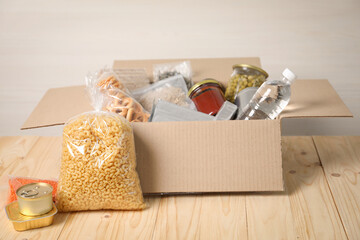 Different food products in box on wooden table