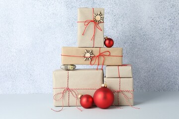 Many gift boxes wrapped in kraft paper and Christmas decor on light table