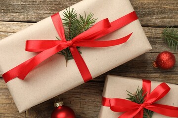 Gifts wrapped in kraft paper and Christmas decor on wooden background, flat lay