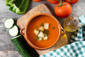 Traditional Spanish Gazpacho soup in bowl on wooden table. Top view
