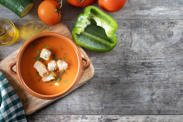 Traditional Spanish Gazpacho soup in bowl on wooden table. Top view. Copy space