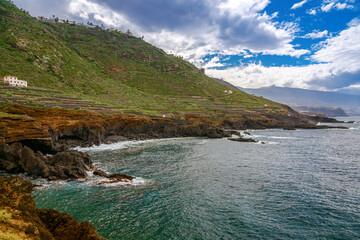 Stunning view of the rugged coastline of El Sauzal, Tenerife, featuring lush green hillsides, rocky cliffs, and the Atlantic Ocean