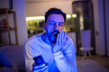 Sleepy man watching TV late at night.