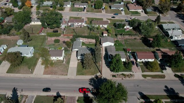 Drone footage moving parallel with a street revealing homes in a neighborhood