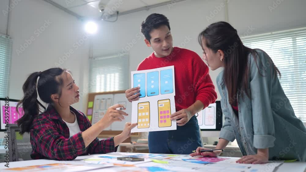 Poster professional ux designers collaborating in modern office, reviewing mobile app interface sketches an