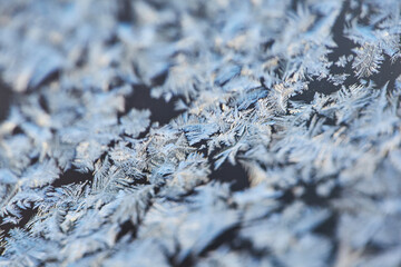 Frost Patterns: Abstract Ice Formations on a Window. Detailed shot highlighting the delicate and frosty patterns formed by freezing temperatures.