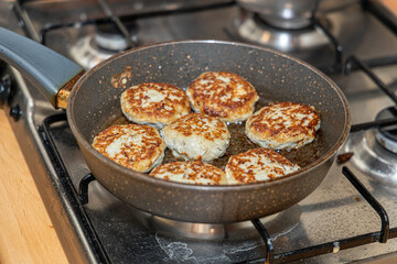 Meat burgers or cutlet-shaped patty being shallow fried in oil on a frying pan, close up. version of cutlets - kotlety.