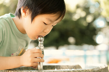 公園で水を飲む男の子