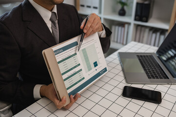 a businessman is studying information in a document to gain a better understanding, a department head is reviewing statistical documents sent by his subordinates, accountant, office