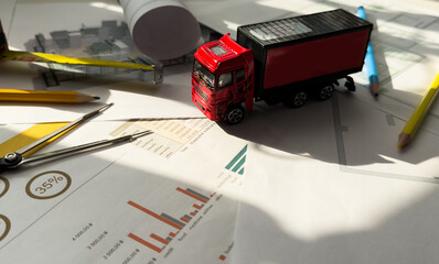 Paper graph and toy truck. Translation: sales, expenses, profits