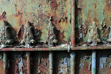 Grille en fer forgé rouillée et couverte de couches de peinture