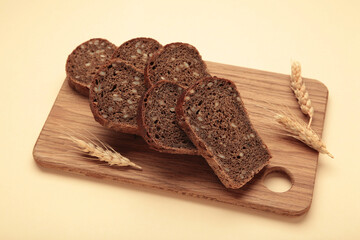 Slice of wholemeal dark bread on beige background
