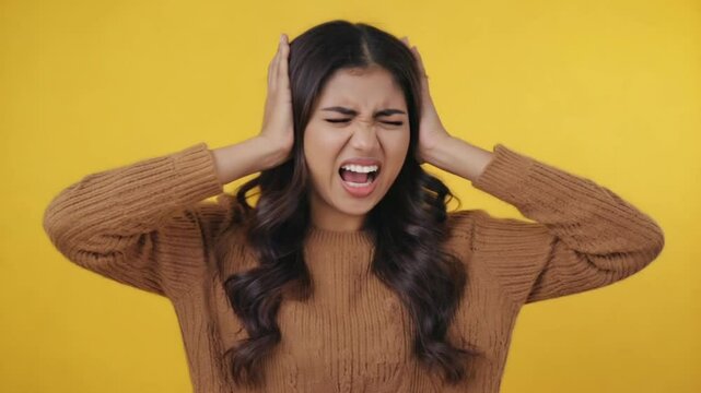 Young stressed woman covering her ears to protect herself from loud noise 