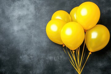 Cluster of vibrant yellow balloons against a dark gray backdrop.