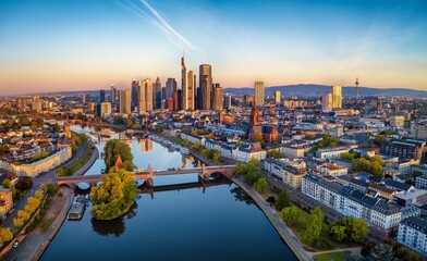 Panoramic aerial view of the skyline of Frankfurt am Main, Germany, with golden sunrise light reflecting on the office skyscrapers