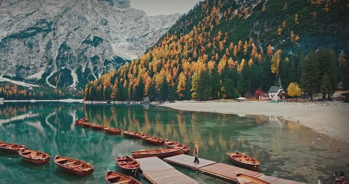 he enchanting Lago di Braies Lake in the Dolomite Mountains of Italy is a natural wonder with its magnificent nature and reflections. The drone moves backwards.