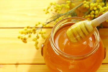 Honey dripping and glass jar full of honey                               