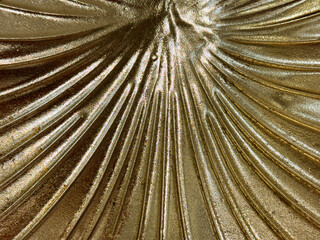 Close up of gold metallic trumpet sunburst pattern, made of forged metal plate. Iron monger and...