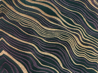 Close up of fabric and wallpaper with random gold wavy pattern on dark blue background. Luxurious and elegant graphic background resources. Seamless background texture.