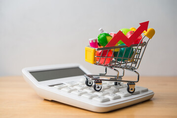 Vegetables, fruits, drinks, food material in supermarket trolley and calculator on wooden table....