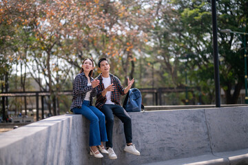 Obraz premium A man and a woman are sitting on a wall