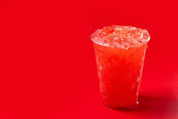Red strawberry slushie on red background. Copy space