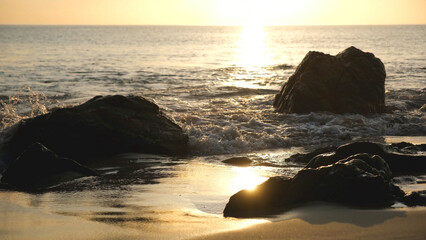 The sea, rocks and water wave with a beautiful sunset sky