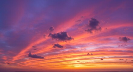 Obraz premium Fiery Sky at Dusk: A breathtaking panorama of a vibrant sunset with fiery hues of orange, pink and purple, creating a dramatic and awe-inspiring spectacle against a backdrop of clouds. 