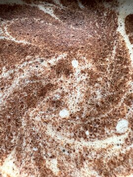 Macro de polvos de canela con aspecto floral, sobre la espuma del caf&eacute; con leche, primer plano, formato vertical