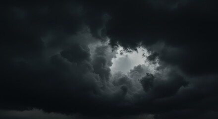 Fototapeta premium Dramatic Sky: A striking image of a moody, dramatic sky dominated by swirling dark clouds, with a glimpse of ethereal light breaking through, offering a sense of both awe and introspection.