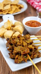 CloseUp of Sate Ketoprak Jakarta with Peanut Dressing and Crackers with Sambal Kecap 