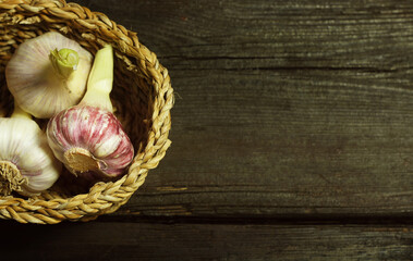 Fresh garlic in a basket on a wooden table