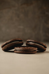Delicious dark chocolate cookies stacked on a rustic surface in warm light