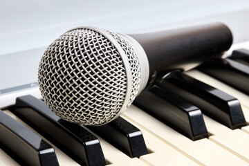 Microphone on midi piano keyboard keys. Recording studio concept.