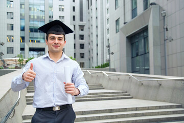 Happy man portrait on her graduation day University. Education and people. Man thumbs up.